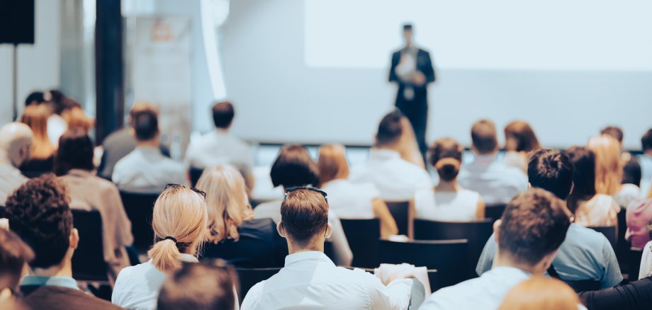 Business speaker giving a talk at business conference event.
